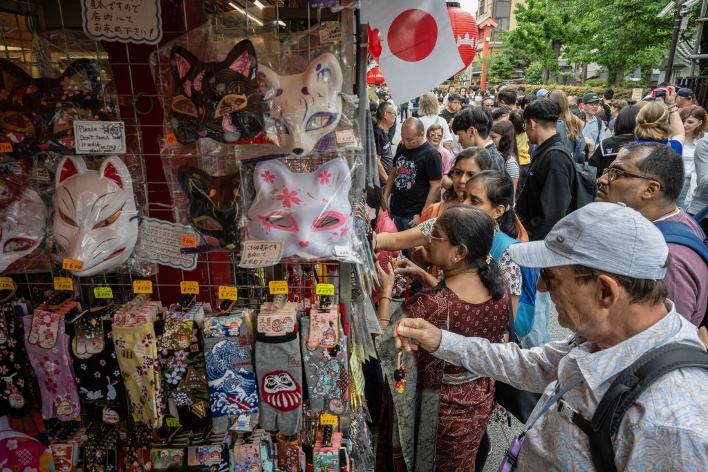 Tourists shop at a souvenir store on Nakamise shopping street near Sensoji Temple in Tokyo on April 30, 2024.