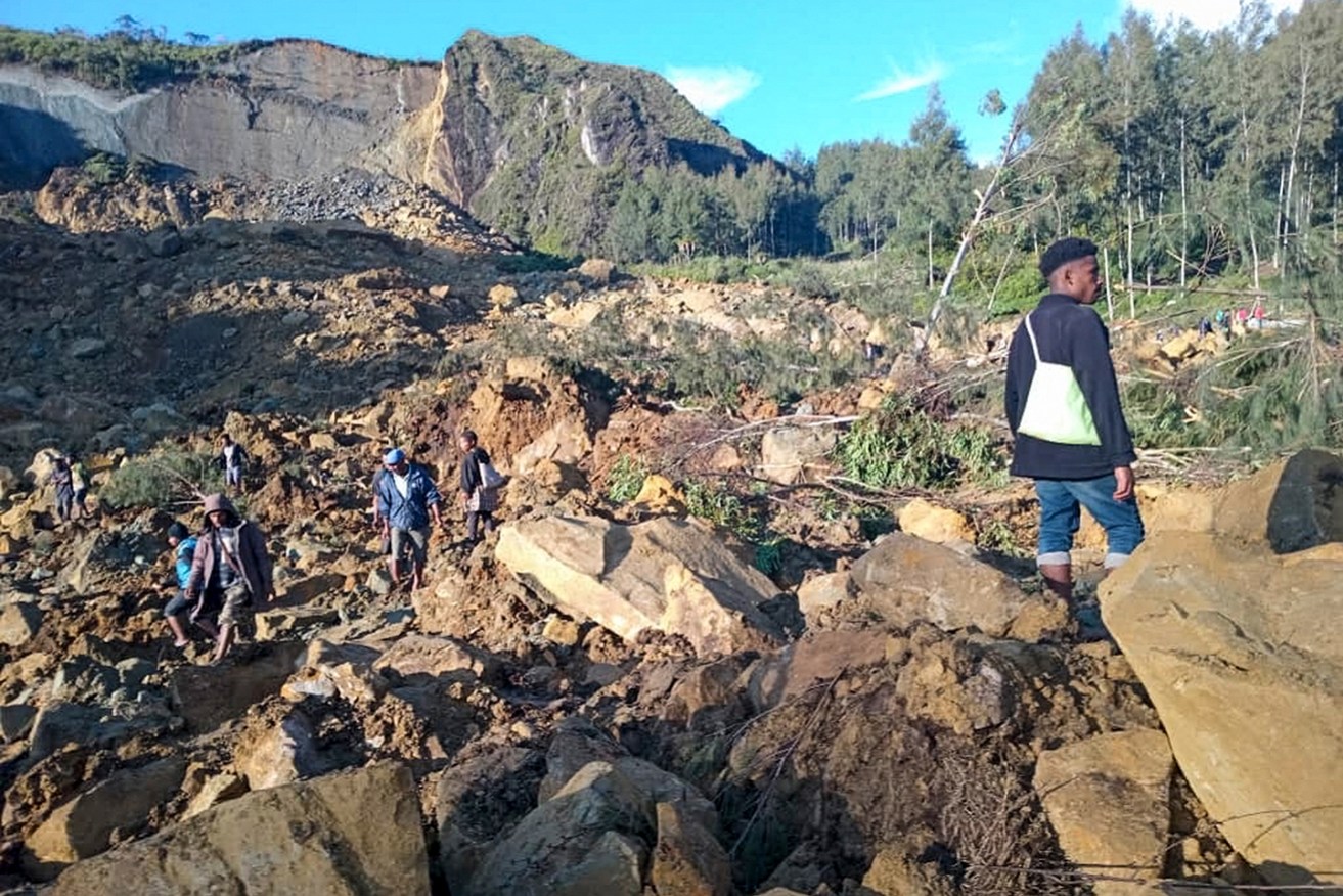 People gather at the site of a landslide in Maip Mulitaka in Papua New Guinea's Enga Province.  