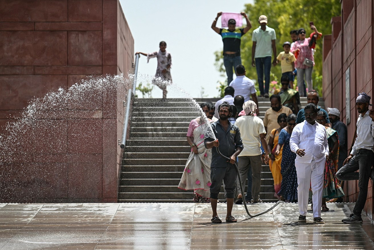 A worker sprinkles water during a heatwave in New Delhi on Wednesday when temperatures soared to a record-high 49.9 degrees Celsius.