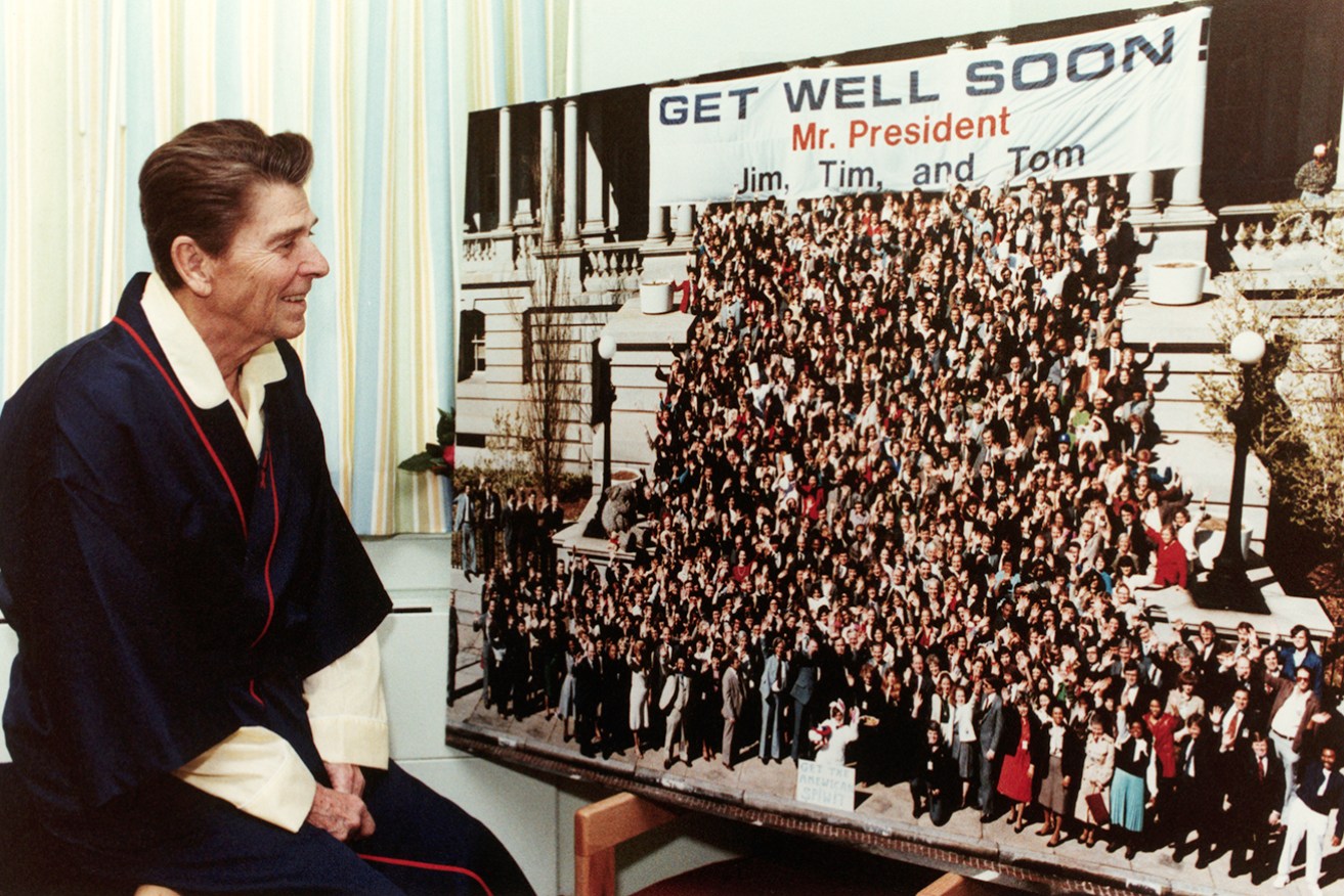 US President Ronald Reagan views a get-well card while recuperating from his gunshot wound suffered in an assassination attempt.