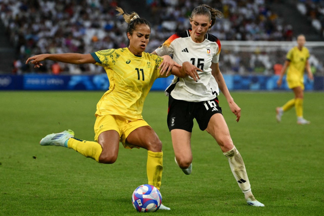 Mary Fowler tussles with Germany's midfielder Jule Brand in Marseille.