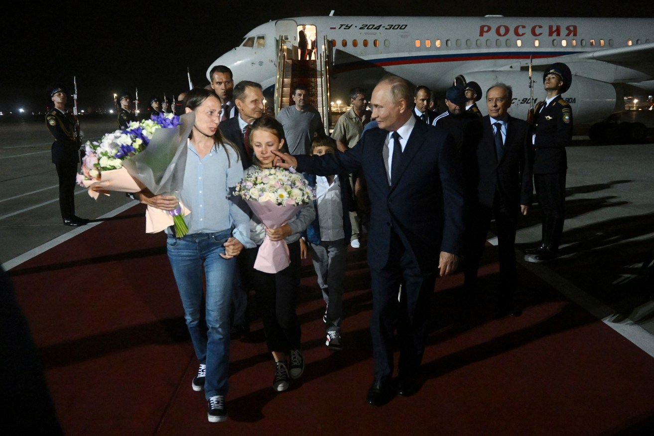 Russian President Vladimir Putin walks with released Russian prisoners and relatives upon their arrival in Moscow.