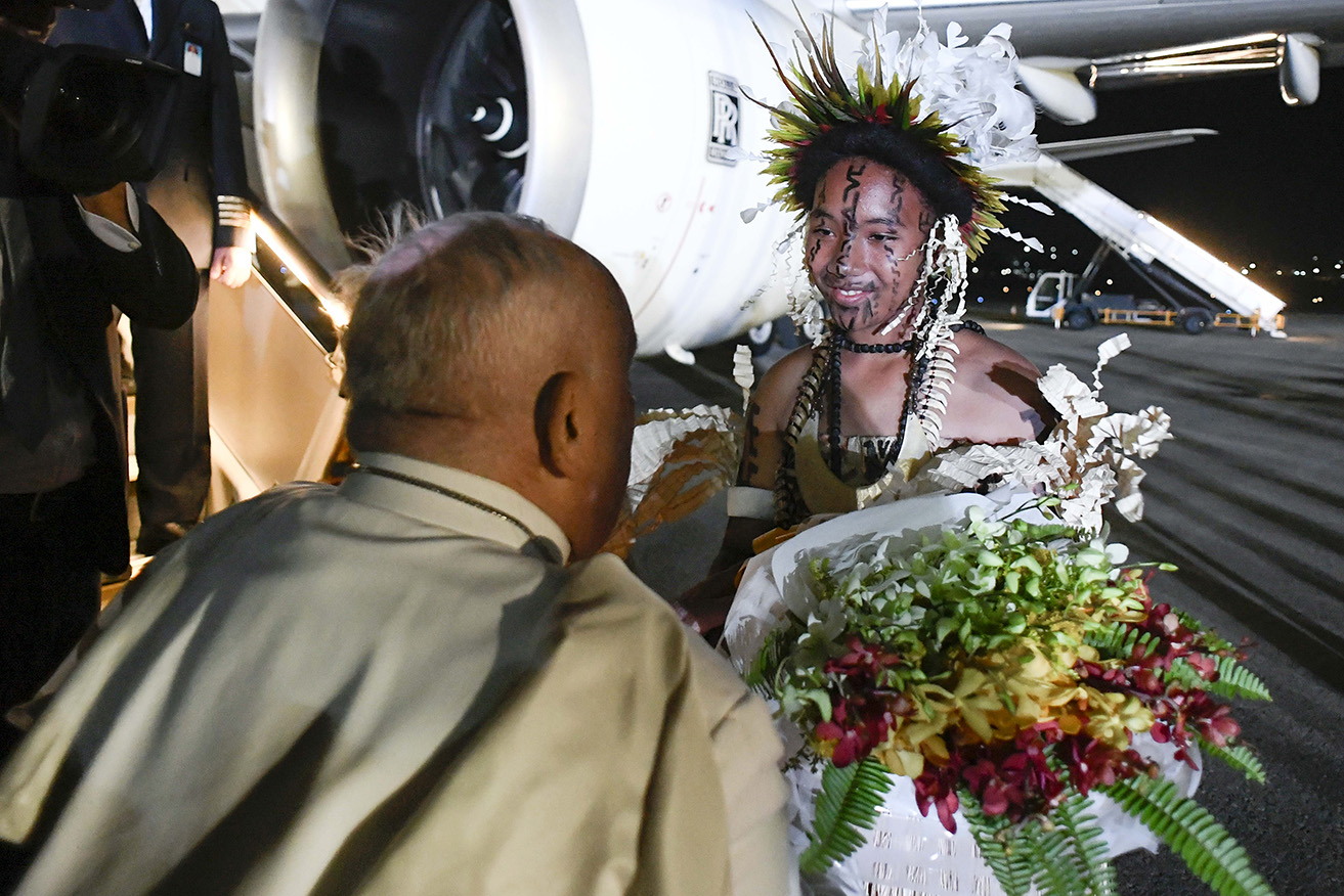 Pope Francis has donned a traditional hat to meet Catholics living in Papua New Guinea.