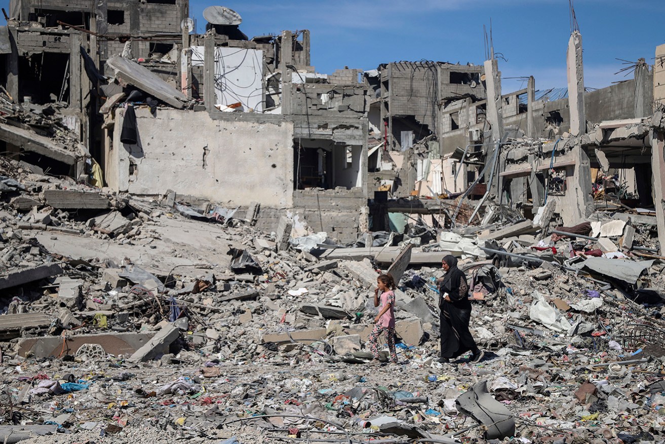 Palestinians search for missing people under the rubble of a destroyed UN-run school in Nuseirat.