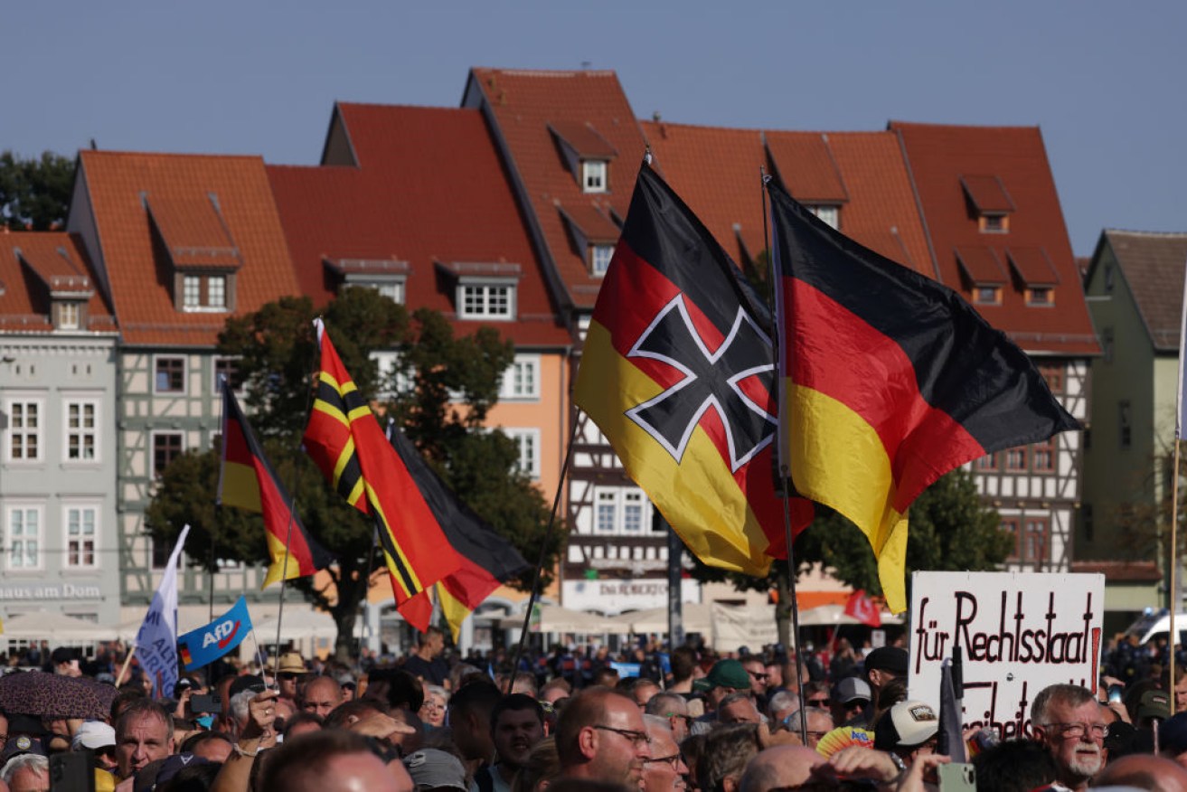 Supporters of the far-right Alternative for Germany (AfD) political party wave German flags, including one adorned with an Iron Cross, in Thuringia.