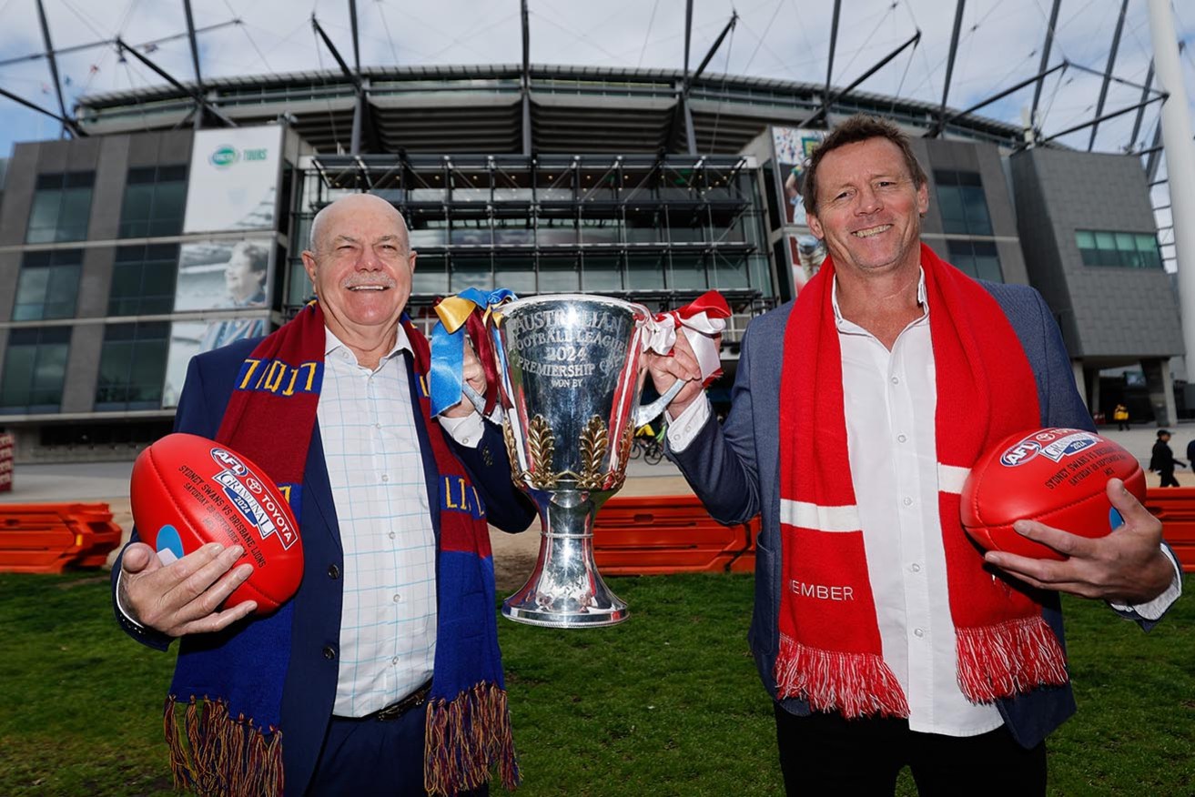 AFL premiership cup presenters Leigh Matthews (Brisbane Lions) and Stuart Maxfield (Sydney Swans) prepare for Saturday’s grand final at the MCG.