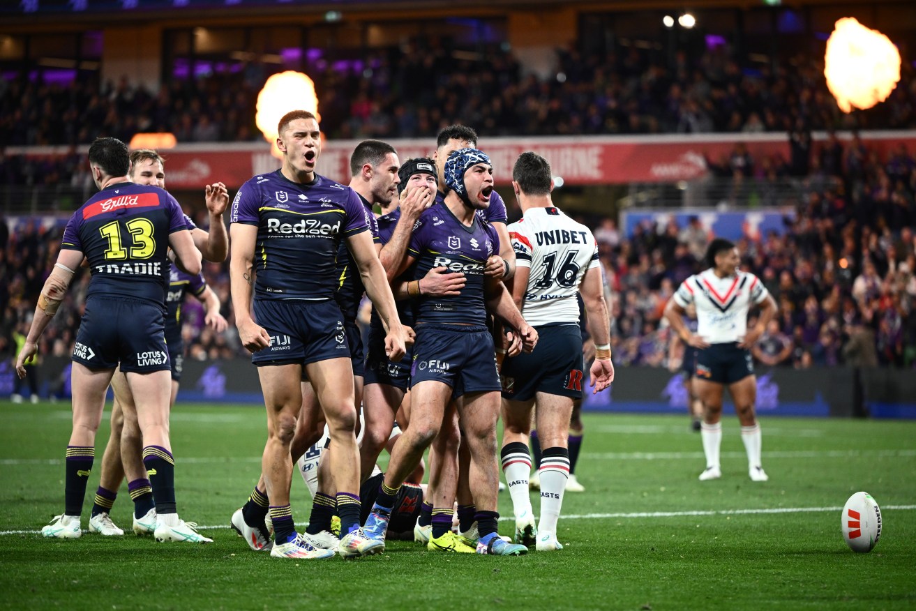 Jahrome Hughes celebrates scoring a try with Storm teammates.