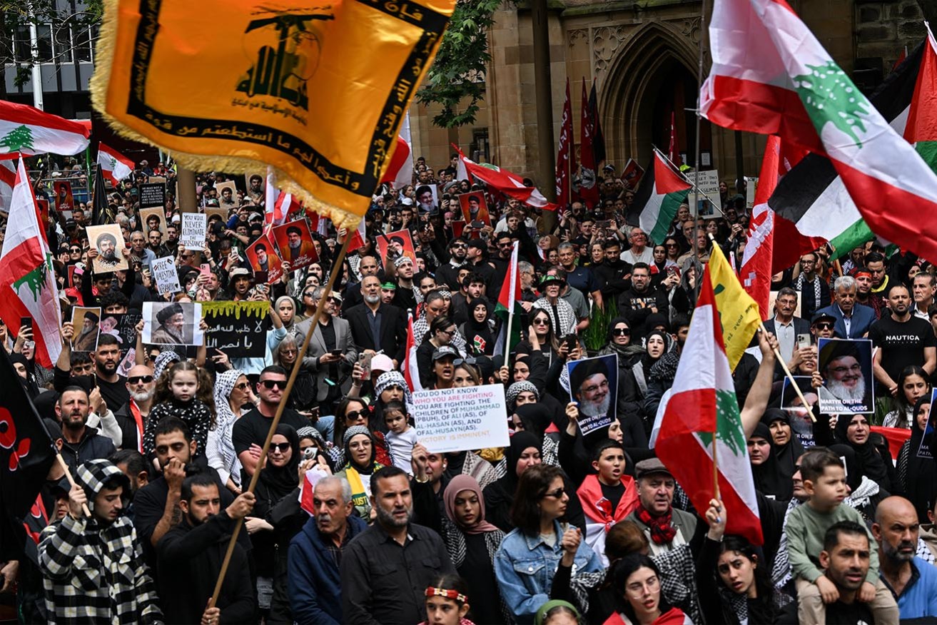 Hundreds of demonstrators hold flags and pictures of Hassan Nasrallah, late leader of the Lebanese group Hezbollah, at a protest rally in Sydney on September 29,.