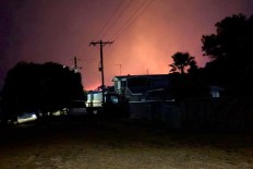 Seaside hamlet under threat as bushfire rages