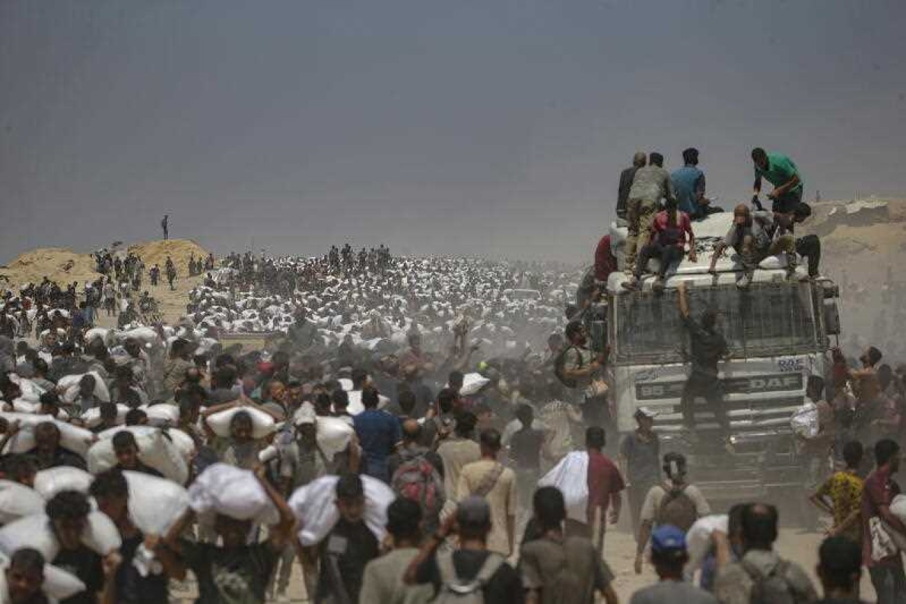 Gaza residents carry bags of flour after lorries with food aid were allowed into the enclave.