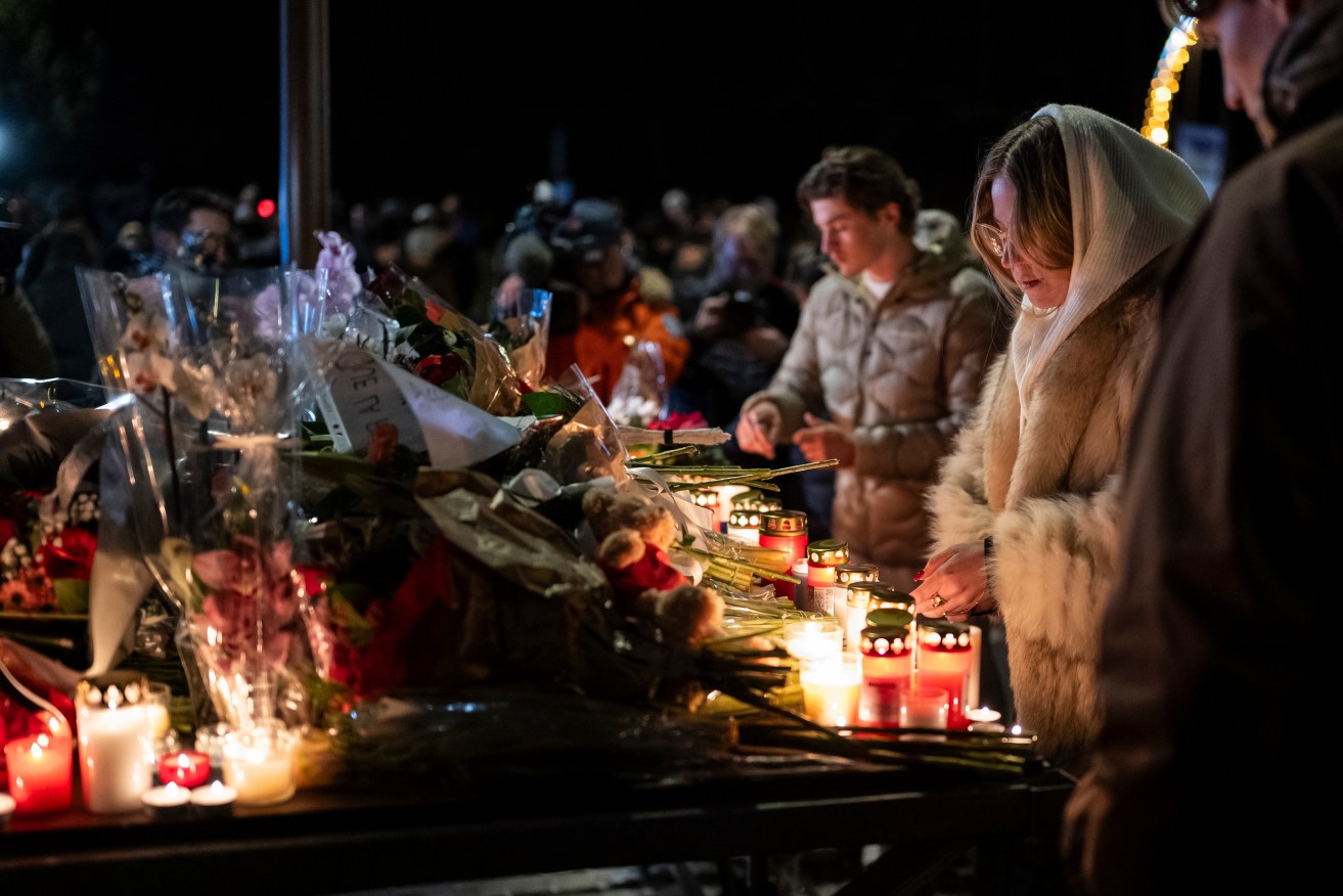 Mourners lay flowers and light candles after the deadly fire in the Swiss Alps.