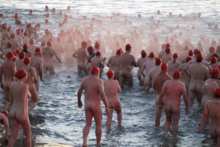 Thousands grin and bare it for solstice swim