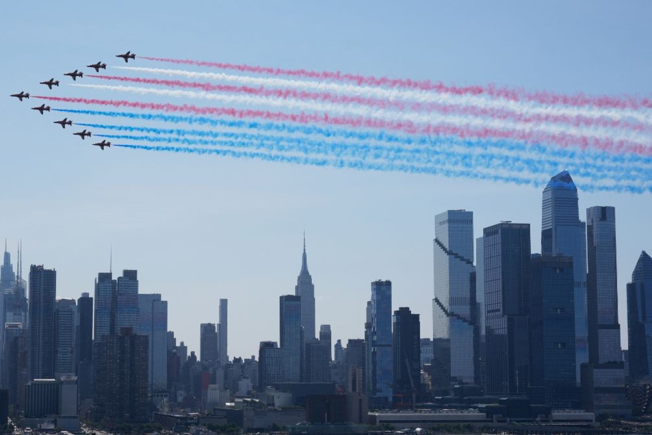 Military planes perform a flyover of the Hudson River above the the Manhattan skyline.